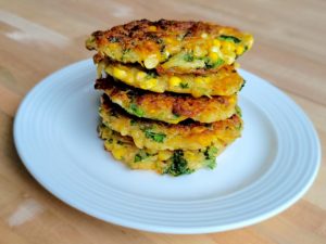 Photo of Kale & Corn Hash Brown Cakes Stacked on a Plate