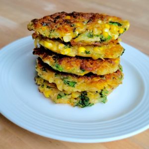 Photo of Kale & Corn Hash Brown Cakes Stacked on a Plate