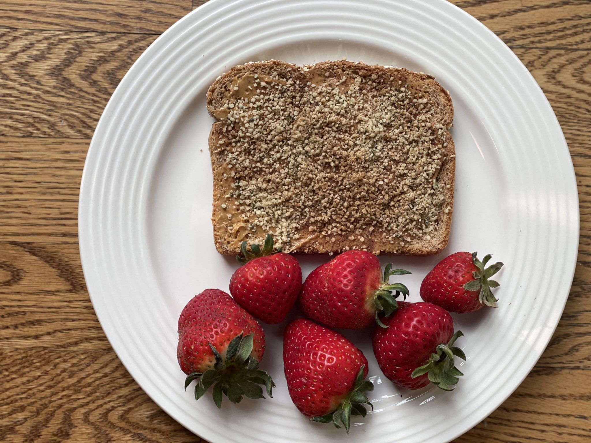 Peanut butter toast with hemp seeds, cinnamon and strawberries